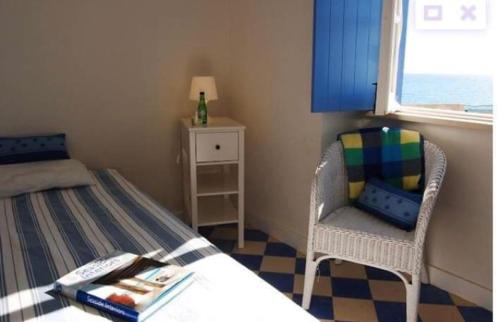 een slaapkamer met een bed, een stoel en een raam bij Casa da Praia in Albufeira