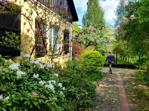 a man walking down a path next to a house at Willa Reglówka in Wola Krakowiańska