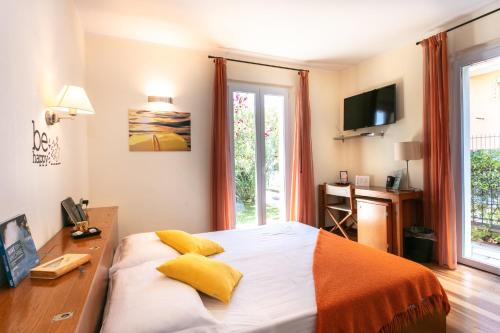 um quarto com uma cama, uma secretária e uma televisão em Oasi Hotel em Levanto