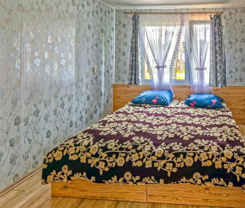 a bedroom with a large bed with blue pillows at Ośrodek Vantur in Księże Młyny