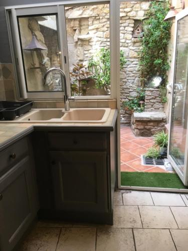 a kitchen with a sink and a large window at La 54 Provence in LʼIsle-sur-la-Sorgue