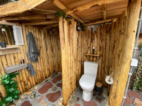 a wooden bathroom with a toilet and a sink at Basic luxury yurt in Egmond aan den Hoef