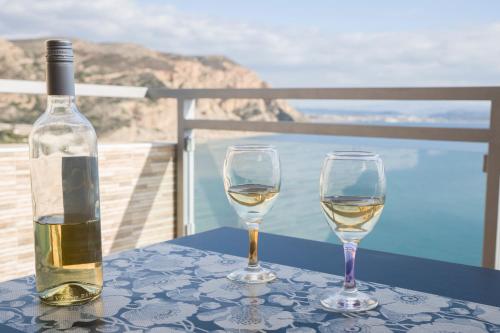 two glasses of white wine sitting on a table at Minos Boutique Hotel in Agia Galini