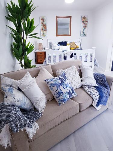 a couch with pillows on it in a living room at Black Sheep Cottage Hay in Hay