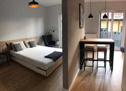 a bedroom with a bed and a table and a dining room at Loft Dragoner Kaserne Olsztyn in Olsztyn