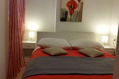 a bedroom with a red bed with two pillows at Flowers house on the island in Žman
