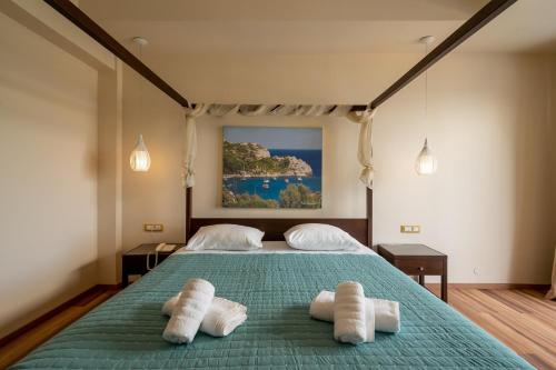 a bedroom with a bed with two towels on it at Ladiko Suites - Faliraki in Faliraki