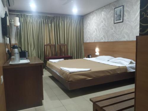 Old Goa Residency في أولد غوا: غرفه فندقيه بسرير وكرسيين