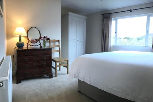 a bedroom with a bed and a mirror and a dresser at Strone in Boath