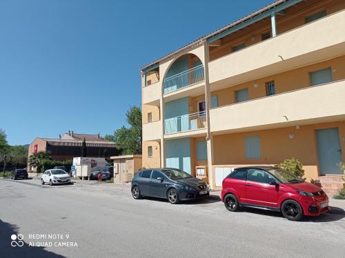 deux voitures garées devant un bâtiment dans l'établissement Un nid d'amour en Provence à deux pas de la mer, à Cogolin