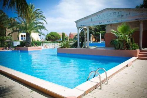 une piscine dans un complexe hôtelier avec des palmiers dans l'établissement Appartement avec terrasse bodega, à Canet