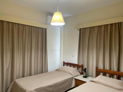 Habitación de hotel con 2 camas y luz en Terpsithea Apartments en Ayia Napa