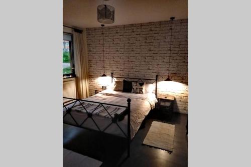 a bedroom with a bed with a brick wall at La Monica 3 - Cazare Straja - Lupeni - Retezat - Parang in Lupeni