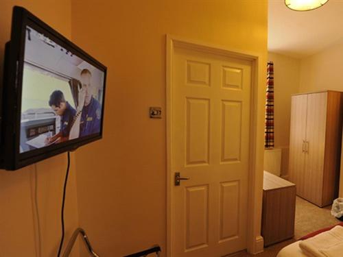uma televisão de ecrã plano pendurada numa parede em Gail's Guest House em Barry