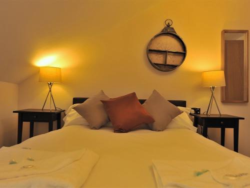a bedroom with a white bed with two lamps at Gail's Guest House in Barry