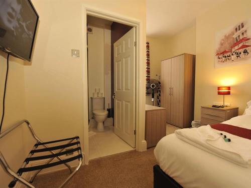 a hotel room with a bed and a bathroom at Gail's Guest House in Barry