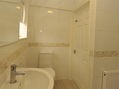 ein weißes Bad mit einem WC und einem Waschbecken in der Unterkunft Gail's Guest House in Barry