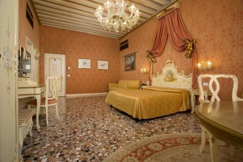a bedroom with a bed and a table and a piano at Locanda Cà Le Vele in Venice