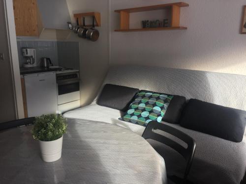 a small living room with a couch and a table at Studio Village des Longes in Le Mont-Dore