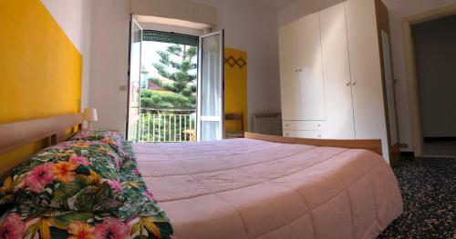 een slaapkamer met een groot bed en een groot raam bij Appartamento in pieno centro a 100m dal mare in Spotorno