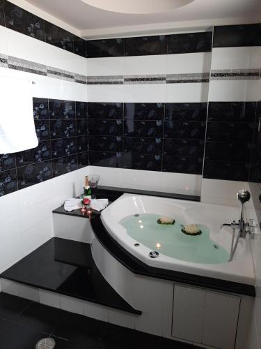 a bath tub in a bathroom with black and white tiles at Rhodian Villa in Kremasti