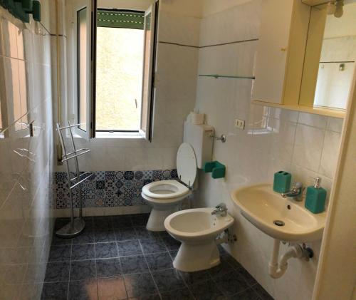 a bathroom with a toilet and a sink at Appartamento in pieno centro a 100m dal mare in Spotorno