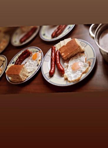 a table with plates of breakfast food on it at Woden apartment in Žabljak
