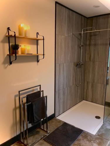 a bathroom with a shower with a glass wall at Trelaske Mill Cider Barn-with Hot Tub, Fire Pit BBQ in Lewannick