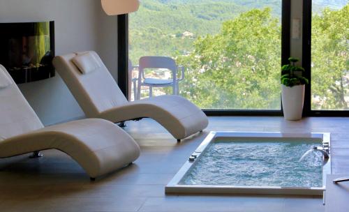 a spa room with a hot tub and a chair at Petit Mirador in Torrelles de Llobregat