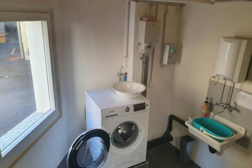 een wasmachine in een kamer met een wastafel bij Classy Apartment in Interlaken