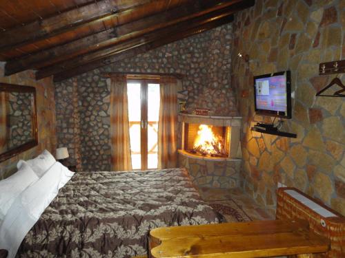 - une chambre avec un lit et une cheminée dans l'établissement KALAVRITA INN, à Kalavrita