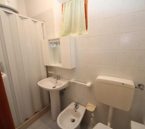 Baño pequeño con aseo y lavamanos en Villa Manu appartamento 02, en Rosolina Mare