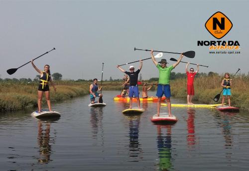 a group of people on paddle boards in the water at Ria de Aveiro White House in Murtosa