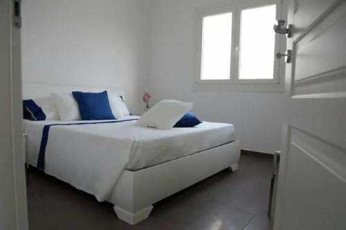 una camera bianca con un letto e un computer portatile di COSTA FENICIA RESIDENCE - Aura Club a Scoglitti