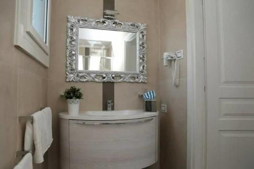 een badkamer met een wastafel en een spiegel aan de muur bij COSTA FENICIA RESIDENCE Prenotabile da Sabato a Sabato in Scoglitti