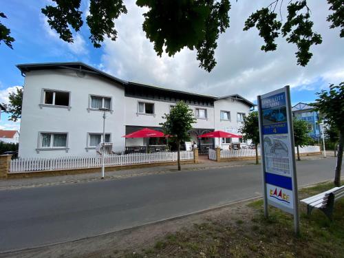a white building with a sign in front of it at Hotel Altes Kurhaus in Baabe