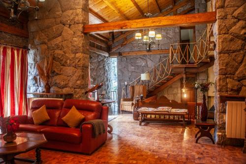 sala de estar con sofá y pared de piedra en Hotel Vallibierna en Benasque