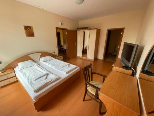 a bedroom with a bed and a desk and a tv at Borovets Holiday Apartments - Different Locations in Borovets in Borovets