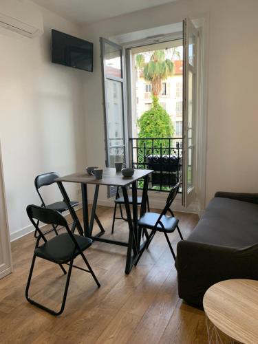 un salon avec une table, des chaises et un canapé dans l'établissement Nice Centre: à 300m de la mer et de la Promenade des Anglais, à Nice