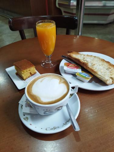 une tasse de café, du pain et un verre de jus d'orange dans l'établissement Espe Daga Apartamento, à Bueu