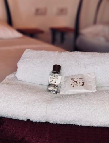 a bottle of soap sitting on top of towels on a bed at Stone House Obelisk in Gjirokastër