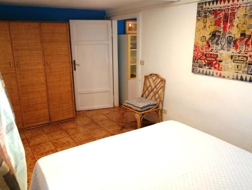 a bedroom with two beds and a chair and a door at Cavo Beach 3 in Cavo