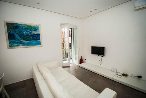 a white living room with a white couch and a tv at Luxury Apartments Manarola by Arbaspàa in Manarola