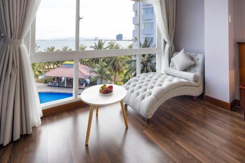 - un salon avec un canapé, une table et une fenêtre dans l'établissement Saigon - Ninh Chu Hotel & Resort, à Phan Rang