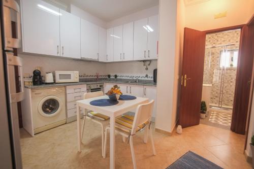 a kitchen with a white table and chairs in a kitchen at Familia Sequeira in Nazaré