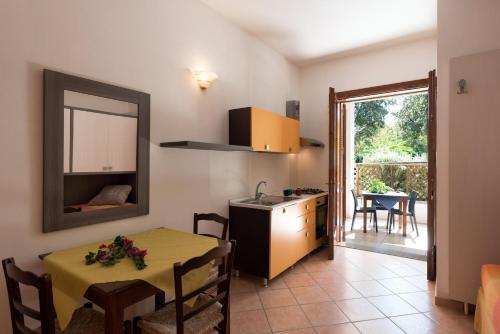 eine Küche und ein Esszimmer mit einem Tisch und einem Spiegel in der Unterkunft Residence Costa d’Otranto in Otranto