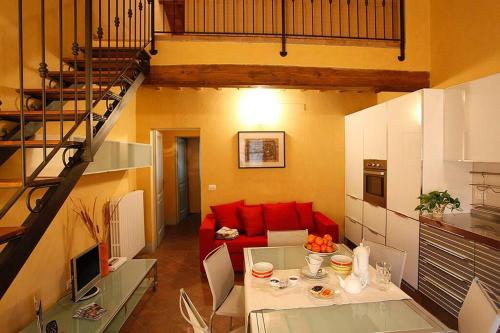 a living room with a red couch and a table at Appartamento Il Leccio Pian delle more in Sassetta