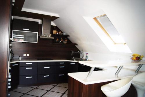 a kitchen with black and white cabinets and a sink at Pokoje Gościnne U Bosmana in Dźwirzyno