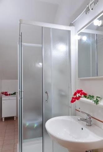 a bathroom with a glass shower and a sink at Residence Costa d’Otranto in Otranto