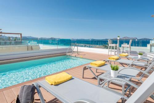 a group of chairs and a pool on a building at Llaut Boutique Hotel in Can Picafort
